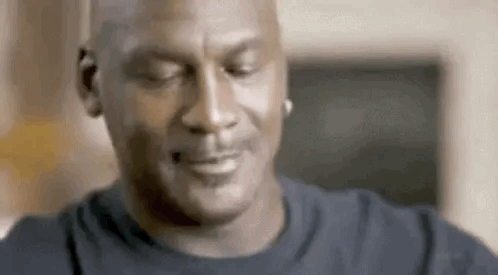 Michael Jordan closes his eyes with a resigned, confused smile.