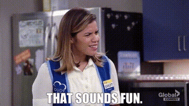 a woman in a blue vest is standing in a kitchen with the words `` that sounds fun '' written on the screen .