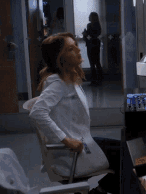 Amelia Shepherd from Grey’s Anatomy leans back with a hand at her side.