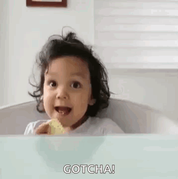 A smiling toddler in a bathtub raises a thumb with “GOTCHA!” text.
