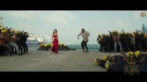 a woman in a red dress is dancing in front of a crowd of people .