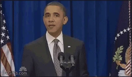 Barack Obama speaks at a podium in front of American flags.
