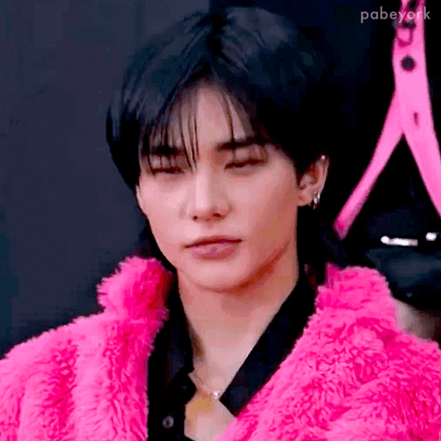 a close up of a person wearing a pink fur coat