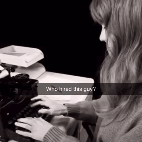 a woman is typing on an old typewriter with a caption that says who hired this guy