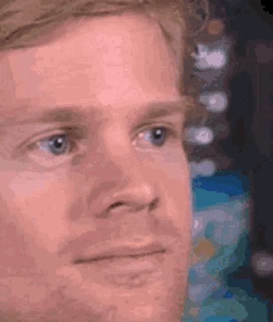 A man looks sideways with a stunned, uncertain expression.