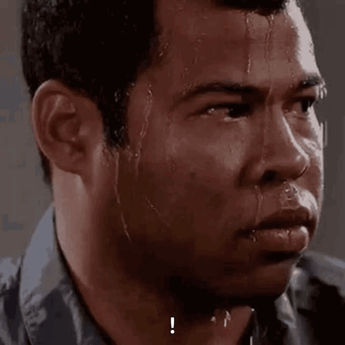 A sweaty man stares ahead with an intensely nervous expression.