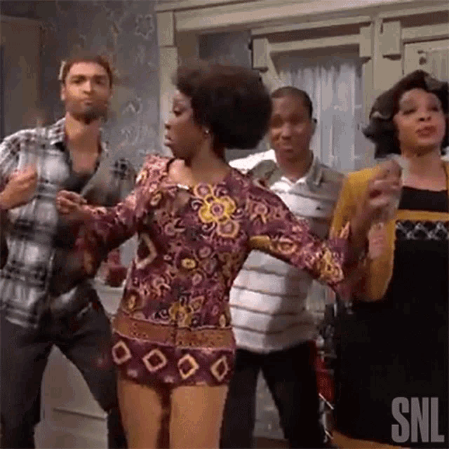 a group of people are dancing together in a room in front of a window .