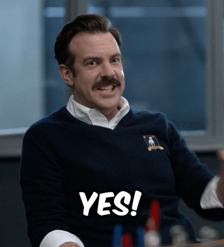 Ted Lasso smiles with emphatic “YES!” text.