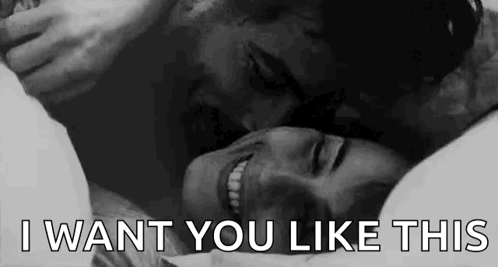 A grayscale couple cuddles with “I WANT YOU LIKE THIS” text.