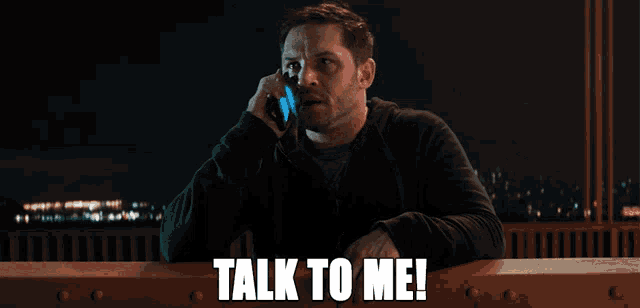 a man is talking on a cell phone with the words talk to me below him