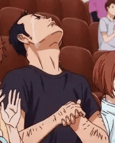 Anime character leans back laughing while clapping in a cinema.