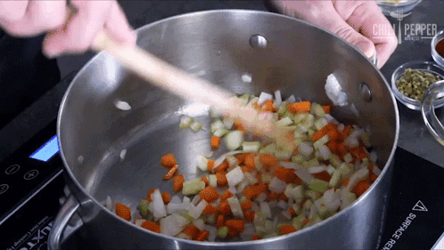 a pot of vegetables is being stirred with a wooden spoon on a surface that says surface protector