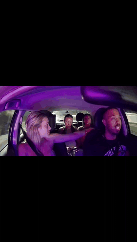 a group of people are sitting in a car with a man wearing a shirt that says still play