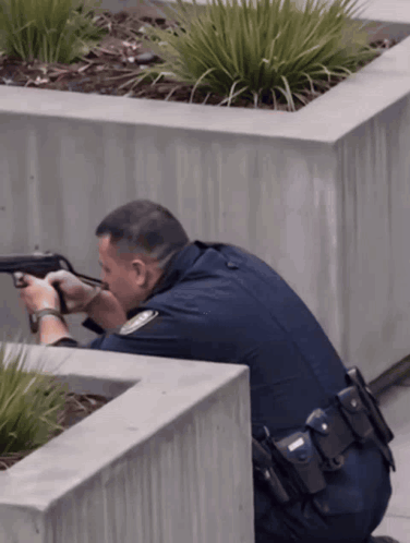a police officer kneeling down holding a gun