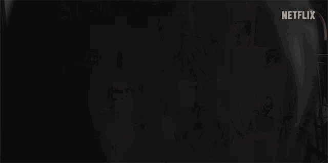 a man standing in a dark room with a netflix logo on the bottom