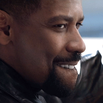 A man smiles knowingly in close-up.