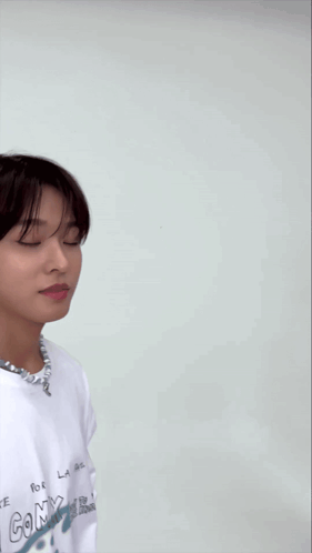 a young man wearing a white shirt with the word la on the front
