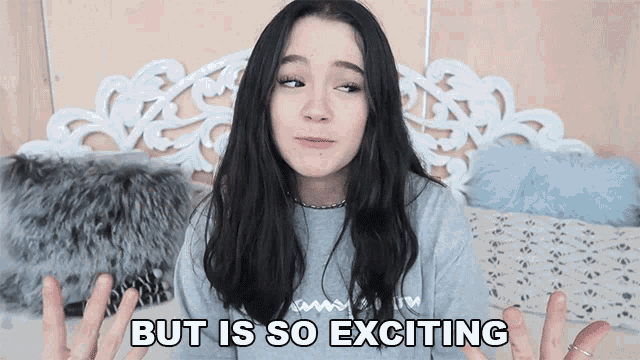 a girl says but is so exciting in front of a bed with pillows