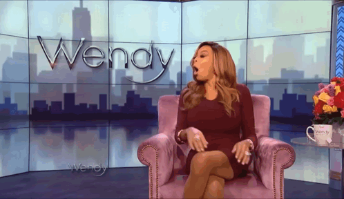 a woman sitting in front of a screen that says wendy on it