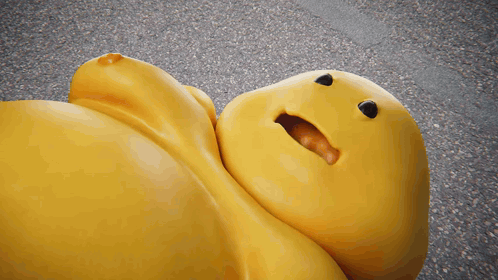 a yellow stuffed animal with a smile on its face is laying on the ground