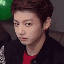 Jungkook looks sideways with a subtle smile.