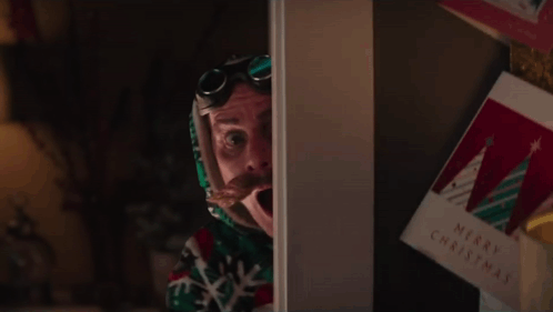a man with a surprised look on his face is standing in front of a christmas card