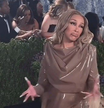 Doja Cat shrugs while seated at a formal event.