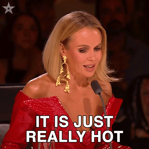 a woman in a red dress says it is just really hot in front of a microphone