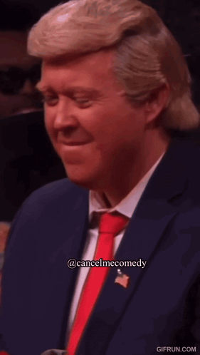 Donald Trump sits at a microphone with a displeased expression.
