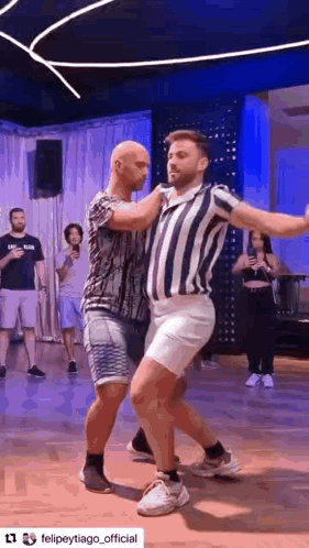 two men are dancing together in a dance studio .