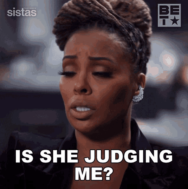 a woman says " is she judging me " while wearing earrings