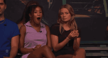 a woman in a purple shirt is sitting next to another woman in a black shirt