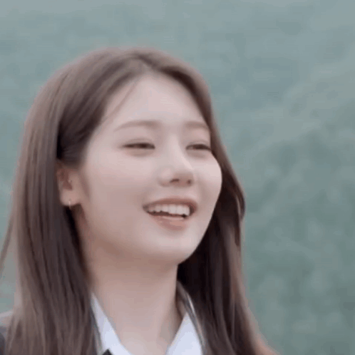 a close up of a young woman smiling with her eyes closed and her mouth open .