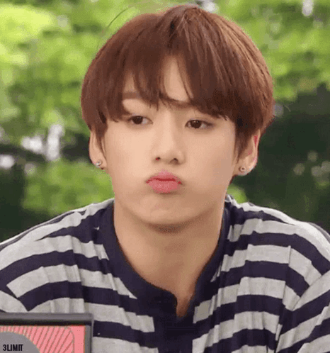 A man in a striped shirt pouts toward the camera.