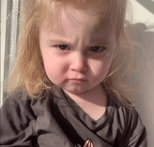 A young child frowns intensely at the camera.