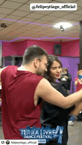a man and a woman are dancing in a dance studio sponsored by terra livre