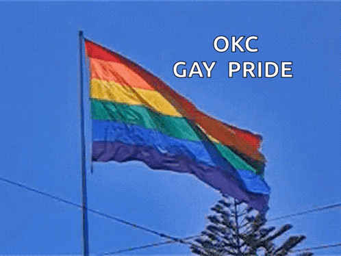 a rainbow flag is flying in the wind with okc gay pride written above it
