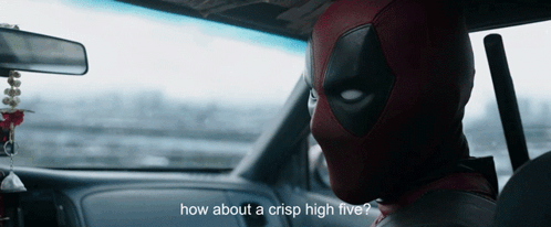 a man in a deadpool costume is sitting in the driver 's seat of a car
