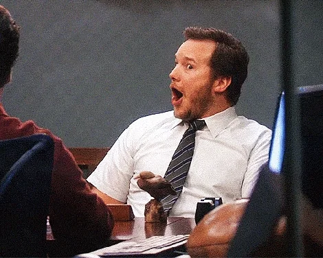 Andy Dwyer opens his mouth in a shocked, excited reaction.