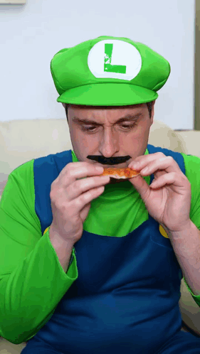 a man in a luigi costume eating a piece of pizza
