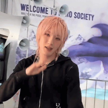 a person with pink hair is standing in front of a sign that says welcome to oxo society