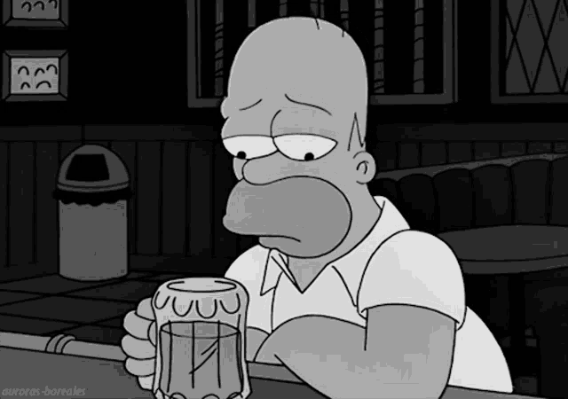 Homer Simpson sits sadly at a bar holding a beer mug.