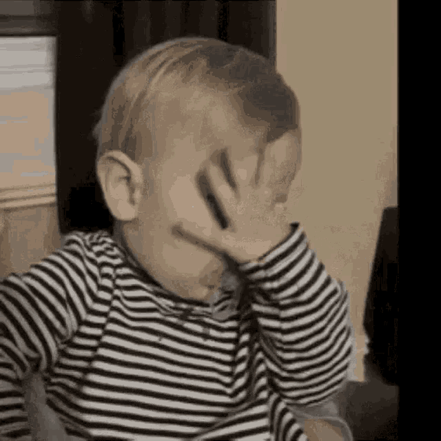 A child covers their face in a full facepalm.