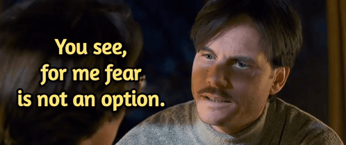 a man with a mustache is talking to another man with the words " you see for me fear is not an option "