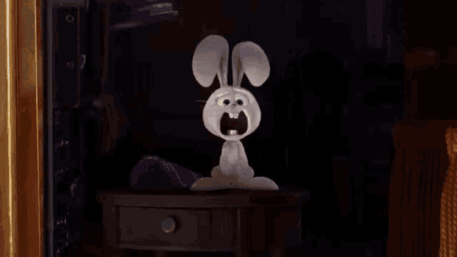 a stuffed bunny is sitting on a table with its mouth open .