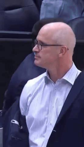 a bald man wearing glasses and a blue suit