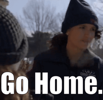 a woman wearing a black hat and a jacket says go home