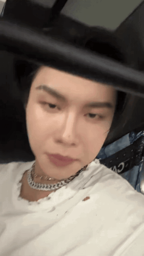 a close up of a person wearing a white shirt and a necklace .