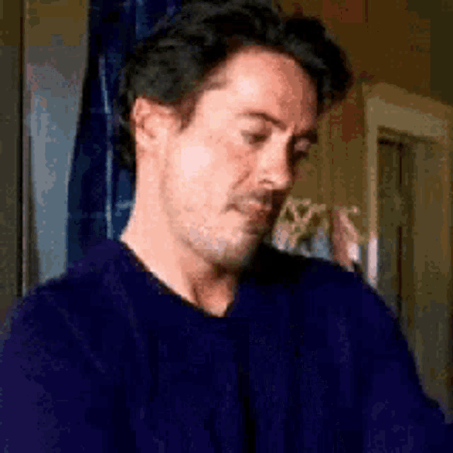 Tony Stark rubs his face with a weary expression.