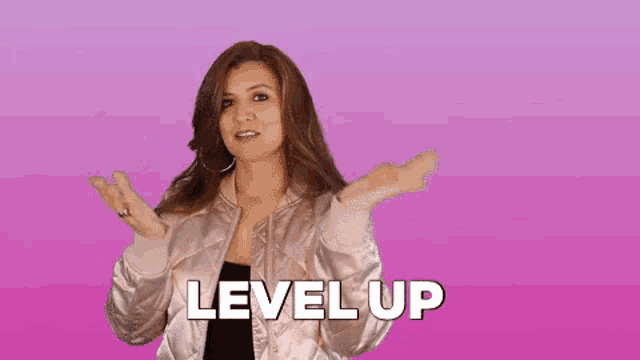 a woman in a bomber jacket is raising her arms in the air and the word level up is written on a pink background .